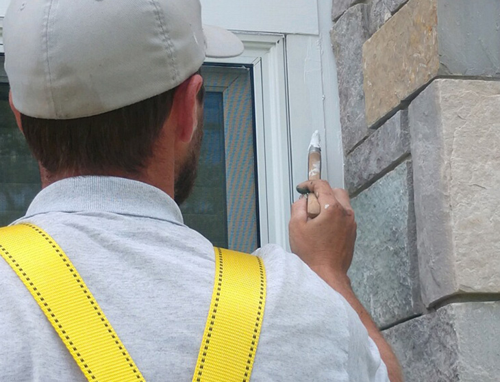 Professional painter painting house trim